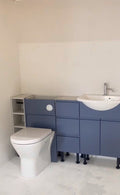 Bathroom training bay with a toilet, blue vanity units and basin at The Plumbing School