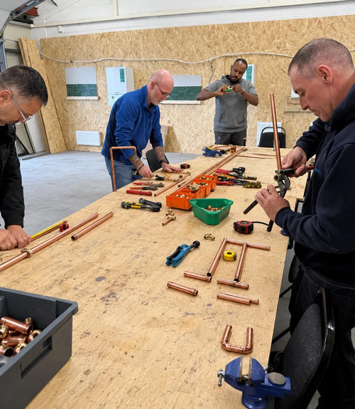 Learners cutting and preparing copper pipe at The Plumbing School
